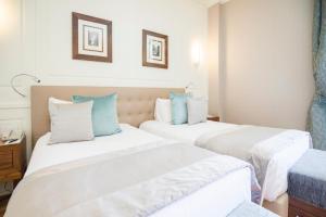 duas camas num quarto de hotel com almofadas brancas e azuis em Grand Hotel Terme Sirmione em Sirmione