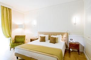 um quarto com uma cama grande e uma cadeira verde em Grand Hotel Terme Sirmione em Sirmione