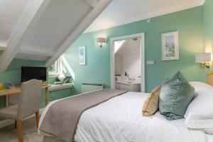 una camera con letto, scrivania e TV di Hotel Penzance a Penzance