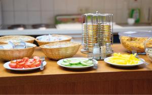 a table with plates of food and bowls of fruit at Radfahrerherberge Krems in Krems an der Donau