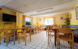 a restaurant with tables and chairs and a flat screen tv at Radfahrerherberge Krems in Krems an der Donau