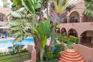 ein Resort mit einem Pool und Palmen in der Unterkunft Airport Hotel Casino du Cap-vert in Dakar