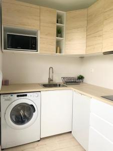 een keuken met een wasmachine en een wastafel bij Studio 30m2 - Au pied de la Gare - PARKING in Cergy