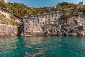 a building on a cliff next to the water at Ravello Art Hotel Marmorata in Ravello