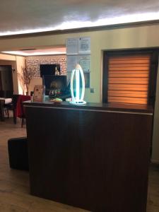 a lobby with a reception desk with a large mirror at Pensiunea El Passo Targu Mures in Târgu-Mureş