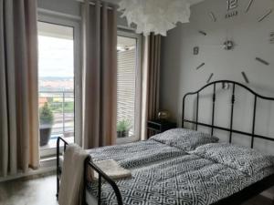 ein Schlafzimmer mit einem Bett mit einer Uhr an der Wand in der Unterkunft Apartament przy Aquaparku w Redzie in Rumia