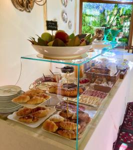 uma vitrine com vários produtos de pastelaria e uma taça de fruta em Hotel Santa Caterina em Siena