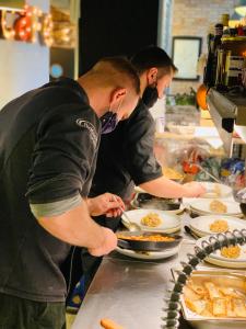 un par de personas preparando comida en una cocina en ApartHostel Warszawa, en Varsovia