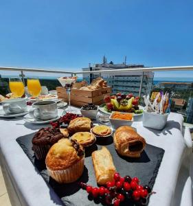 uma mesa com muffins e outros alimentos numa varanda em Monte Gordo Hotel Apartamentos & Spa em Monte Gordo