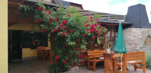 Un bâtiment avec un bouquet de fleurs rouges sur lui dans l'établissement Landgasthof Plohnbachtal UG, à Abhorn