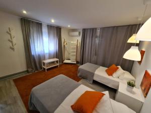 a hotel room with two beds and a couch at NinePlace by LouzanPlace's in Lousã