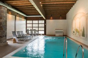 una piscina in una stanza con sedie e tavolo di Jagdschloss Hotel Niederwald a Rüdesheim am Rhein