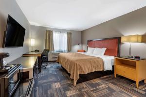 Quality Inn & Suites Evansville Downtown tesisinde bir odada yatak veya yataklar