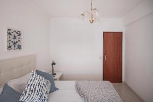 ein Schlafzimmer mit einem Bett und einer braunen Tür in der Unterkunft Zambujeira do Mar 4-Bed House Perfect for Families & Friends in Zambujeira do Mar