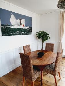 een eetkamer met een houten tafel en stoelen bij Les Sablons - Très Bel Appartement , Lumineux in Saint-Malo