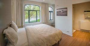 ein Schlafzimmer mit einem Bett und einem großen Fenster in der Unterkunft Villa Fluisterbos in Ostende