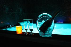 a wine bottle in a glass next to two glasses at Weranda Apartments in Morzyczyn