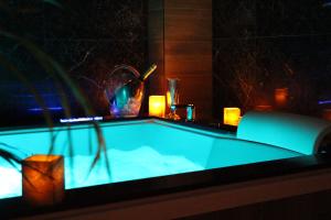 a blue bath tub with a potted plant and candles at Weranda Apartments in Morzyczyn