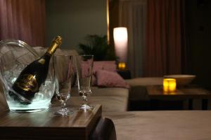 a bottle of champagne sitting on a table with two glasses at Weranda Apartments in Morzyczyn