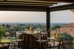 a table with wine glasses on a balcony with a view at Residenza d'Epoca Pietra Di Ponente in Ciampino