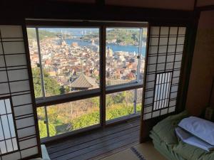 Cette chambre offre une vue sur la ville depuis sa fenêtre. dans l'établissement Onomichi Guest House Miharashi-tei, à Onomichi