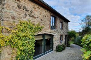 un edificio in pietra con una finestra sul lato di O Près de la Lienne, maison de campagne de charme, accord parfait entre confort et authenticité a Lierneux