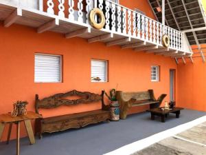 een oranje muur met een bed en een trap bij Villa Solarium Pousada in Cabo Frio