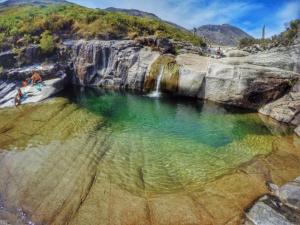 une grande piscine d'eau à côté d'une cascade dans l'établissement Casa Encosta do Gerês-Ferias no Gerês, à Vieira do Minho