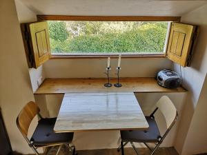 una mesa y sillas en una casa pequeña con ventana en Monte das Cascatas, en Marvão