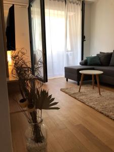 uma sala de estar com um sofá e uma mesa em Apartment IRIS em Novi Sad