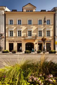 un grand bâtiment avec des personnes assises devant lui dans l'établissement Hotel Teatro Boutique Old Town - Destigo Hotels, à Varsovie