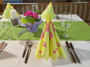 una mesa con un mantel blanco con servilletas. en Berghotel Türlwand, en Ramsau am Dachstein