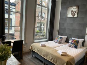 een slaapkamer met 2 bedden en een raam bij Hotel de Prince in Nijmegen