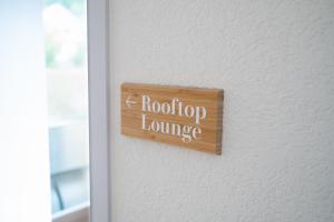 een bord op een deur dat rootipop lounge leest bij la belle vue Boutique Hotel & Café in Spiez