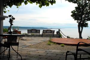 un groupe de bancs assis à côté de l'eau dans l'établissement Gîte Au Perchoir, à Baie-Saint-Paul