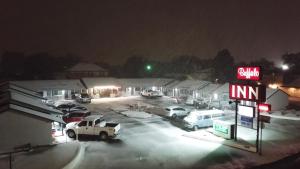 um posto de gasolina à noite com carros estacionados num parque de estacionamento em Buffalo Inn Vintage MOTEL em Canyon