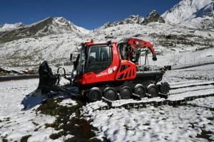 ein roter Bulldozer parkt auf einem schneebedeckten Berg in der Unterkunft Val Thorens Temple of the Sun - ski in, ski out in Val Thorens