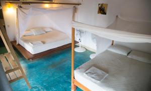 Cette chambre dispose d'un lit et d'un étage avec de l'eau bleue. dans l'établissement Un Sueño Cabañas del Pacífico, à San Agustinillo