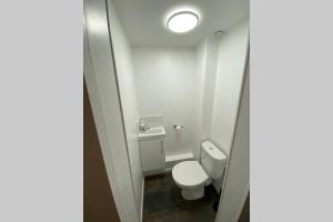 une petite salle de bains avec toilettes et lumière dans l'établissement Le Plongeoir de Bon-Secours, à Saint-Malo