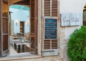 een restaurant met een bord aan de zijkant van een gebouw bij Alcudia Petit - Turismo de Interior in Alcudia