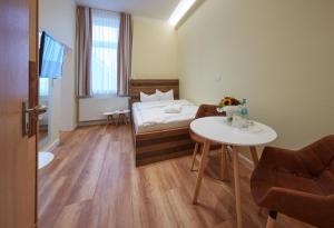 Habitación pequeña con cama y mesa en Strandhotel VierJahresZeiten, en Borkum