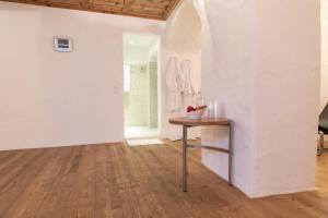 a room with white walls and a wooden floor and a table at Hotel Müller - mountain lodge in Pontresina