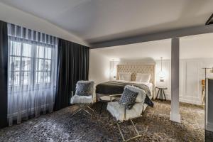 HOTEL BOUTIQUE DONNA ANNA في تيميشوارا: غرفة نوم بسرير كبير وكرسيين