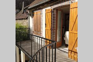 una veranda di una casa con porta in legno di le rempart a Saint-Julien-du-Sault