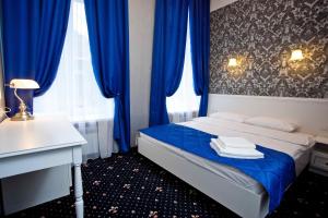 een slaapkamer met blauwe gordijnen en een bed met handdoeken erop bij Hotel Litera in Dnipro