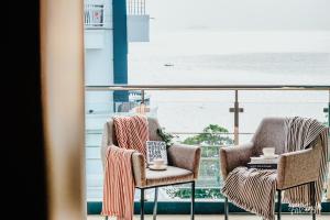 two chairs on a balcony with a view of the ocean at So Boutique Jomtien Beach Pattaya in Jomtien Beach