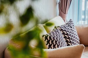 a couch with two pillows on top of it at So Boutique Jomtien Beach Pattaya in Jomtien Beach