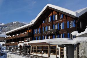 un grande edificio con neve sul tetto di Apartment Jungfrau Lodge a Grindelwald