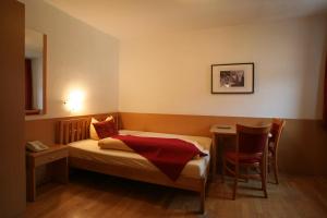 - une petite chambre avec un lit et une table dans l'établissement Hotel Engl, à Innsbruck