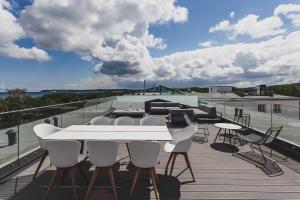 un patio con una mesa blanca y sillas en la azotea en Mariandl am Meer, en Binz